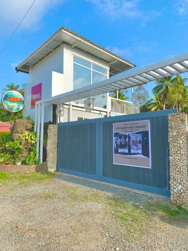 a house with a fence with a sign in front of it at Jardin De Ysabelle in Tagpupungan
