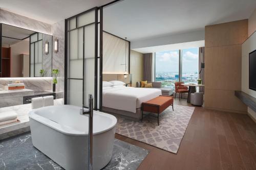 a hotel room with a bed and a bath tub at Hyatt Regency Changshu Kuncheng Lake in Changshu
