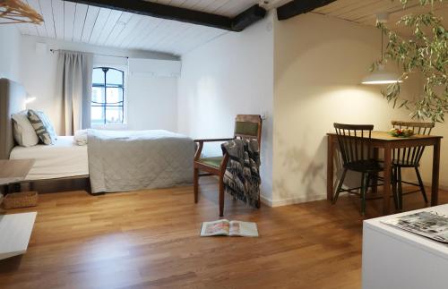 Cette chambre comprend un lit, une table et une cuisine. dans l'établissement Cosy guesthouse in the countryside, with breakfast, à Malmö