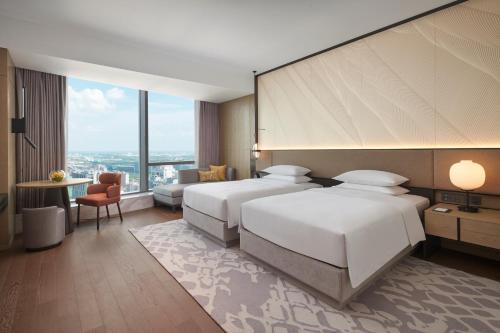 a hotel room with two beds and a large window at Hyatt Regency Changshu Kuncheng Lake in Changshu