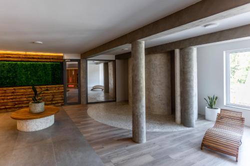 a lobby with columns and a table and a bench at Four Winds in Krynica Morska