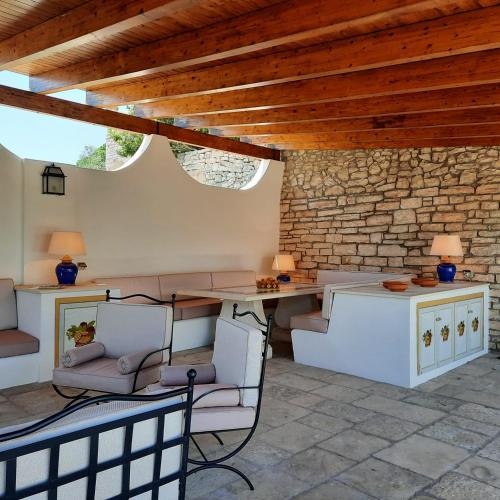 a room with a table and chairs and a stone wall at Villa Anna Buonvino in Giovinazzo