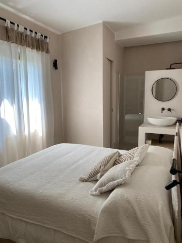a white bedroom with a bed and a sink at Villa Anna Buonvino in Giovinazzo