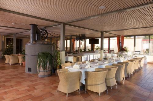 ein Esszimmer mit weißen Tischen und Stühlen in der Unterkunft JUFA Hotel Weinviertel - Eselsmühle in Seefeld