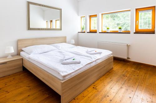 1 dormitorio con 1 cama con sábanas blancas y espejo en Horská chata Harrachov, en Harrachov
