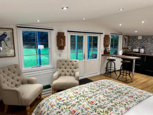 1 dormitorio con 1 cama, 2 sillas y mesa en Oak View Lodge: Cosy, Countryside Retreat, en Maybole