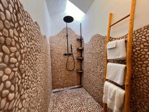 a bathroom with a shower made out of wood slices at Boutique Hostal La Curandera de Salinas in Ibiza Town