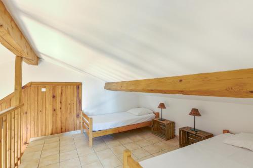 a bedroom with a white bed and wooden ceilings at La Rose des Vents - Gite La Parenthèse in Néoules