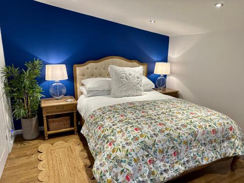 1 dormitorio con 1 cama con paredes azules y 2 lámparas en Oak View Lodge: Cosy, Countryside Retreat, en Maybole