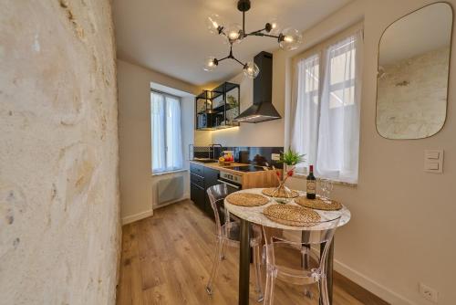uma cozinha com uma mesa com cadeiras e um lavatório em Appartement standing à 7min de Fontainebleau centre, 3min de Moret-sur-Loing et 45min de Paris (1min à pied de la gare) em Veneux-les-Sablons
