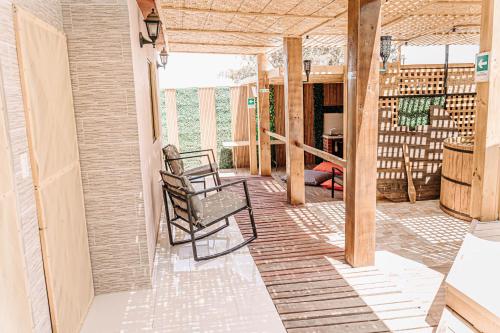 a porch with two chairs on a house at 2 Cabañas para 5 Personas Oasis Pica-Matilla in Pica