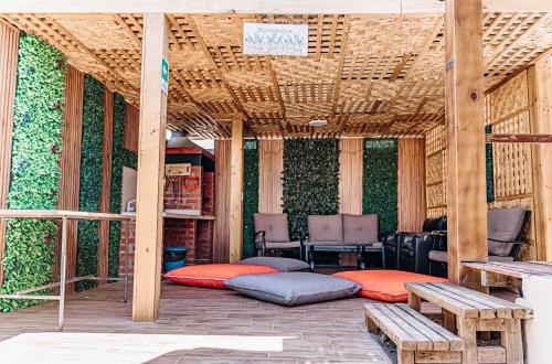 een overdekte patio met kussens en een tafel en banken bij 2 Cabañas para 5 Personas Oasis Pica-Matilla in Pica
