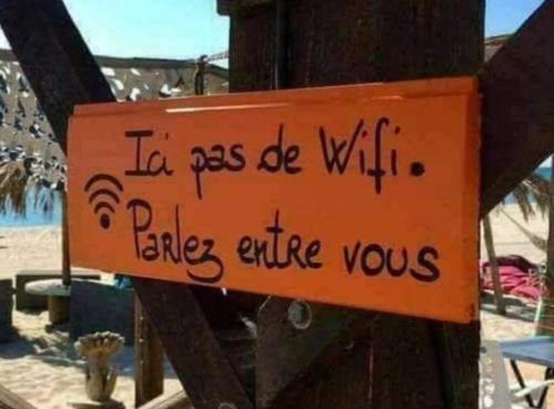 an orange sign on a pole with writing on it at LE GITE DE LA MAISON ROUGE in Anctoville