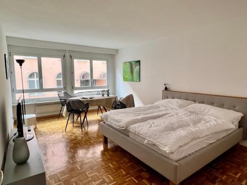 Gemütliche grosse Wohnung Nähe Uni في بازل: غرفة نوم بسرير وطاولة وكراسي