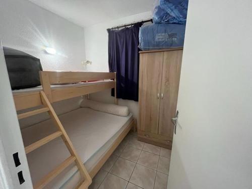 Cette petite chambre dispose de lits superposés et d'une échelle. dans l'établissement Studio Cabine Aux Angles avec Garage et Equipements Complets - FR-1-593-62, aux Angles