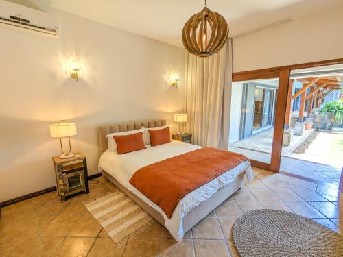 a bedroom with a bed and a large window at Plumeria Villa in Pointe aux Cannoniers