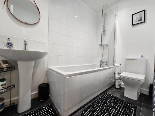 a bathroom with a tub and a sink and a toilet at Guest House - close to all amenities in Northampton