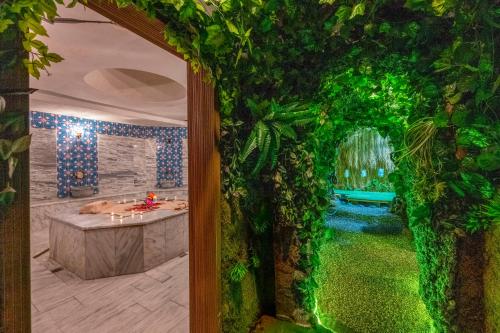 een open deur naar een badkamer met een bad vol klimop bij Litros Hotel & Spa in Istanbul