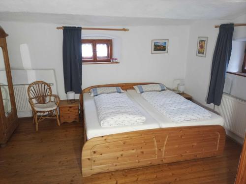 a bedroom with a wooden bed and a chair at Ferienwohnung Alte Schmiede in Beilngries