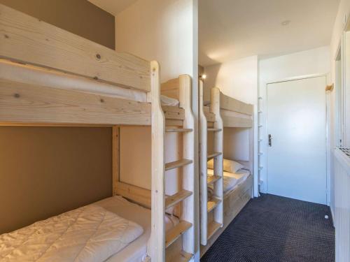 Cette chambre dispose de lits superposés avec 2 lits superposés et une porte. dans l'établissement Studio rénové 6 pers, pied des pistes, terrasses, kitchenette équipée - FR-1-400-121, à Eaux-Bonnes