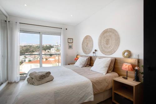 a bedroom with a large bed and a large window at Sea view - dream Nazaré in Nazaré