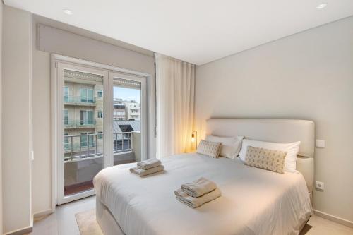 sypialnia z dużym łóżkiem i dużym oknem w obiekcie Póvoa 3 Suites w mieście Póvoa de Varzim