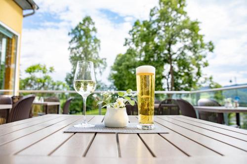 a table with two glasses of beer and a vase at JUFA Hotel Garni Stubenberg am See in Stubenberg