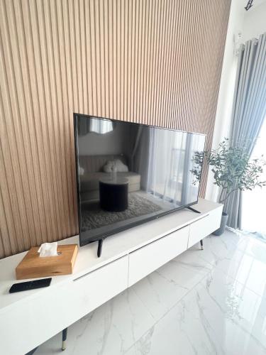 a large flat screen tv sitting on a white table at Apartement 2BR sky house BSD in Cilenggang