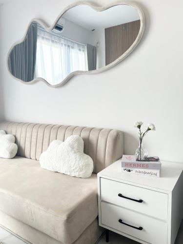 a mirror above a couch with a white dresser at Apartement 2BR sky house BSD in Cilenggang