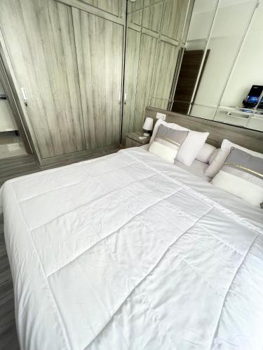 a large white bed with white sheets and pillows at Apartement 2BR sky house BSD in Cilenggang