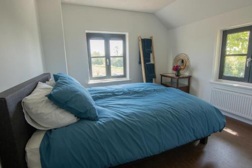 的住宿－Grazelands - overnachten midden in de natuur，一间卧室配有一张带蓝色床单和枕头的床。