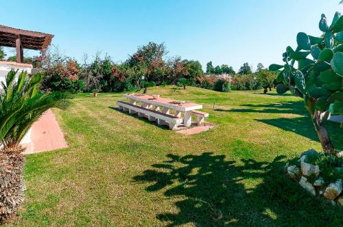 a park with a bench sitting in the grass at Villa con Piscina al Circeo in un oasi di parco in San Felice Circeo