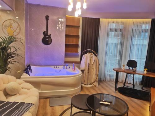 a living room with a tub with a guitar on the wall at SABIHA GOKCEN HOTEL İSTANBUL HOUSES in Istanbul