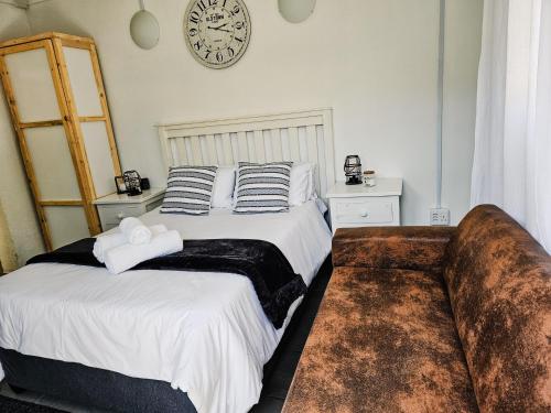 a bedroom with two beds and a clock on the wall at Apartment on 4th Avenue in East London