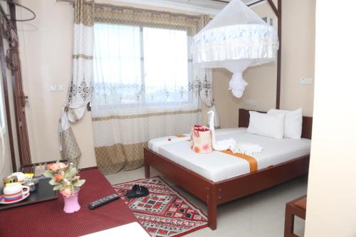 a small bedroom with two beds and a window at Port Park Hotel in Mwanza