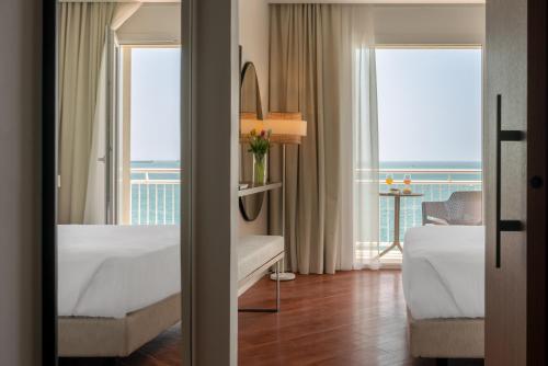una camera d'albergo con due letti e vista sull'oceano di Hotel Delfino Taranto a Taranto