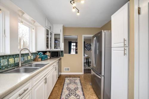 a kitchen with a sink and a refrigerator at 10 Mins To The Big House and Sleeps Up To 10 Guests in Ann Arbor