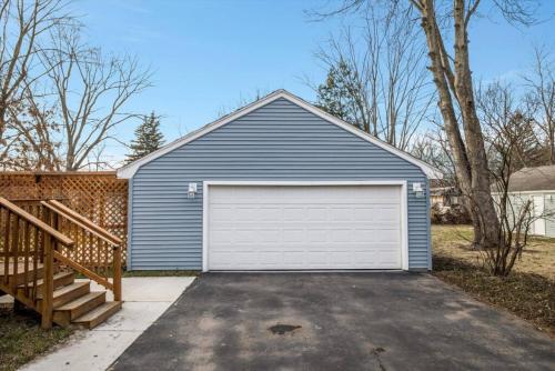 a blue garage with a white garage door at 10 Mins To The Big House and Sleeps Up To 10 Guests in Ann Arbor