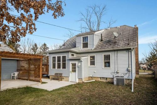 a white house with a gate in the yard at 10 Mins To The Big House and Sleeps Up To 10 Guests in Ann Arbor