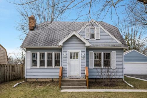 a blue house with a white door at 10 Mins To The Big House and Sleeps Up To 10 Guests in Ann Arbor