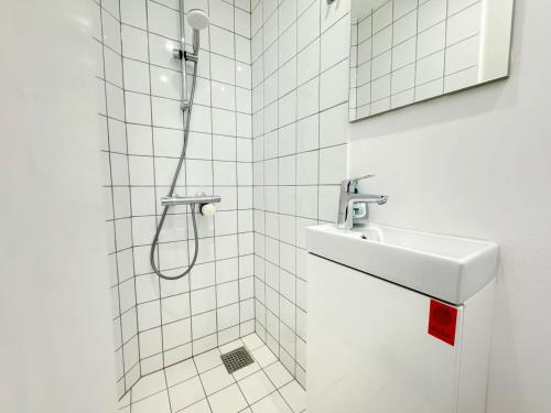 La salle de bains est pourvue d'un lavabo et d'une douche. dans l'établissement Perfect Apartment For Travelers On A Budget - But Still Wants Quality, à Randers