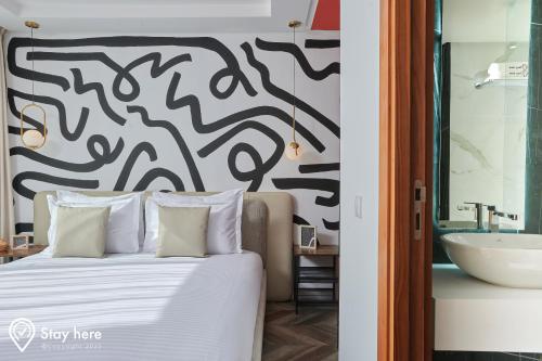 a bedroom with a large bed and a sink at Stayhere Rabat - Agdal 4 - Hotel in Rabat