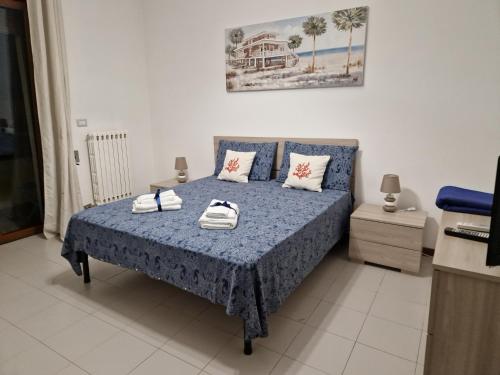 een slaapkamer met een blauw bed en handdoeken bij Casa Rosetta in Lecce