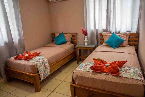 Pokój z dwoma łóżkami z pomarańczowymi łukami w obiekcie Caribbean Villages Aparments w mieście Bocas del Toro