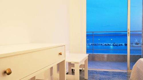 a bedroom with a dresser and a view of the ocean at Porto Evia Boutique Hotel in Amarinthos