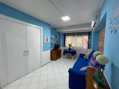 uma sala de estar azul com um sofá e uma mesa em La casa di Dafne em Messina
