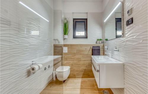 La salle de bains blanche est pourvue de toilettes et d'un lavabo. dans l'établissement Villa La Vrana, à Vrana