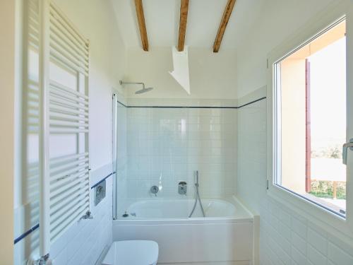 baño blanco con bañera y aseo en Villa Grene - Homelike Villas, en Grosseto