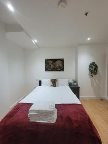 a bedroom with a large white bed with a red blanket at Amazing Canterbury 1 BR Flat in London CB54 in Croydon