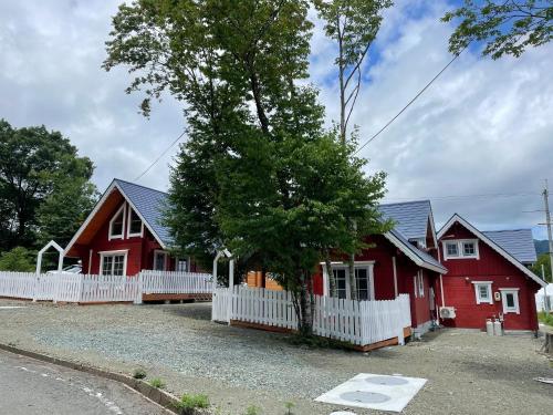 a red house with a white fence at Biwako Hills Resort - Vacation STAY 94635v in Takashima